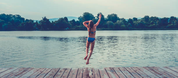 istock Girl jumping into water 841308504