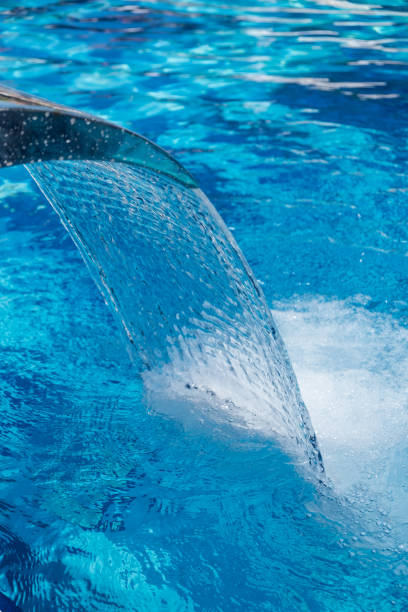 istock Waterfall fountain pouring water int the swimming pool 841308522
