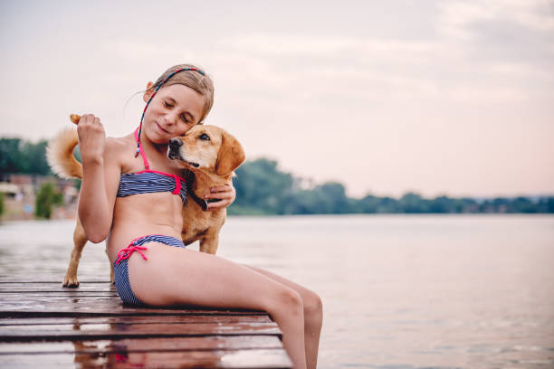 istock Little girl embracing dog on the dock 841311036