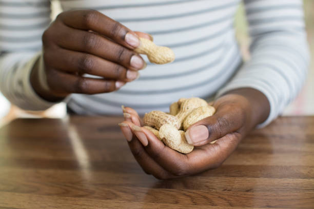 Close Up Of Teenage Girl With Handful Of Peanuts In Shells Close Up Of Teenage Girl With Handful Of Peanuts In Shells peanut food stock pictures, royalty-free photos & images