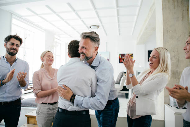Celebrations In Office After Successful Business Pitch By Team An office team are celebrating together, embracing and applauding each other after a successful business pitch. new idea office stock pictures, royalty-free photos & images