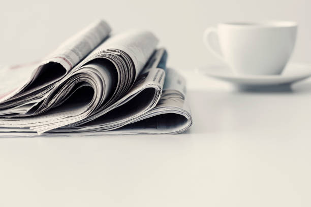 istock Newspaper with a cup of coffee on table 841344664