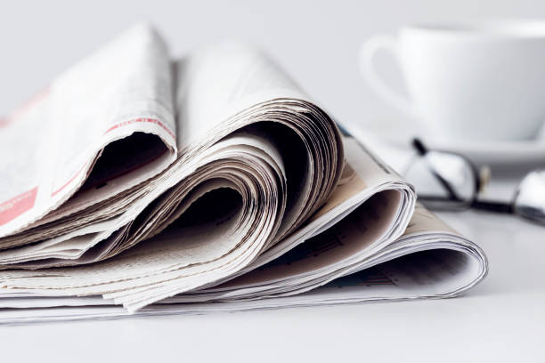 istock Newspaper with a cup of coffee on table 841344918