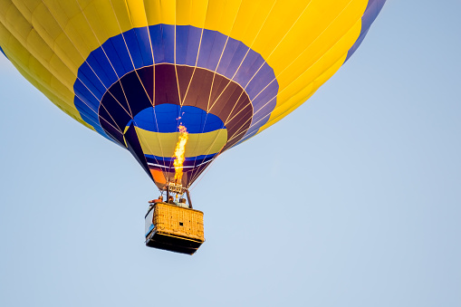 Colorful of Hot air balloon with fire and blue sky background.