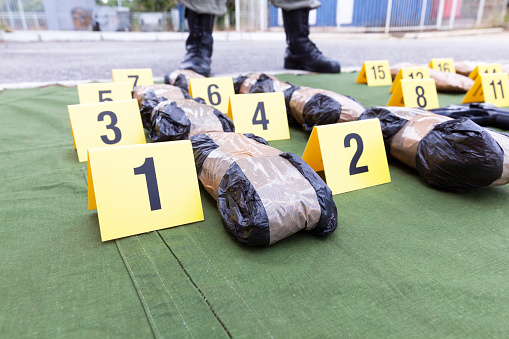 Police officer standing guard over seized packages of drug