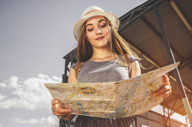 istock Confident girl traveler examining the map. 841351628