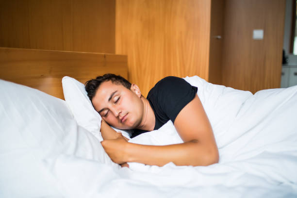 istock Handsome Man comfortably sleeping in his bed at night 841364946