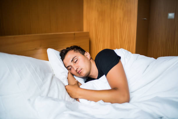 istock Handsome Man comfortably sleeping in his bed at night 841364998