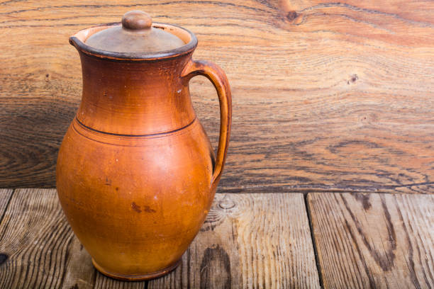 Vintage clay pitchers on wooden background. Studio Photo