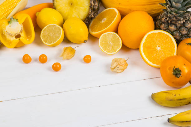 Selection of yellow and orange fruit and vegetables on a table.