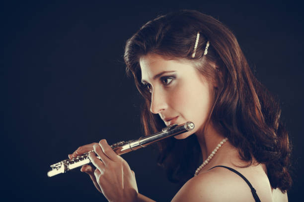istock Woman playing transverse flute on black. 841367992