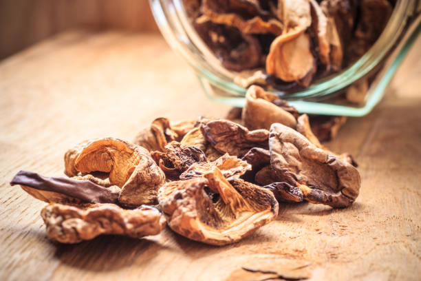 istock Dry mushrooms in jar on wooden table. 841368332