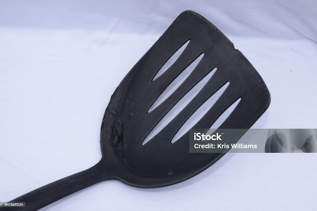 Worn-out black plastic kitchen spatula Bad Condition Stock Photo