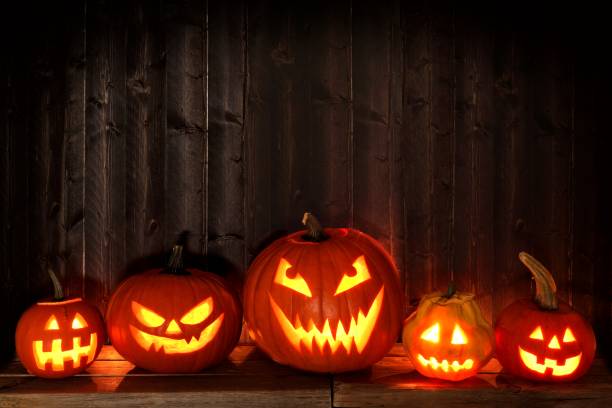 istock Many Halloween Jack o Lanterns at night against dark wood 841372616