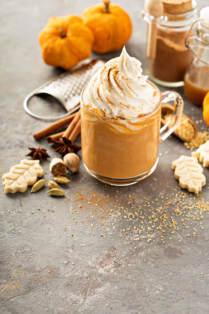 pumpkin spice latte in a glass mug - latté pumpkin spice coffee imagens e fotografias de stock