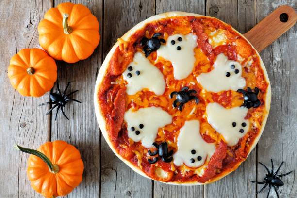 Halloween pizza, above scene with decor on wood Halloween pizza with ghosts and spiders, above scene with decor on a rustic wood background spider photos stock pictures, royalty-free photos & images