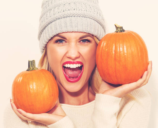 istock Young woman holding pumpkins 841383174