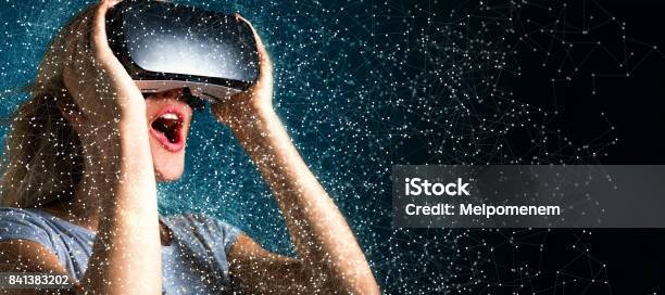 Young Woman Using Virtual Reality Headset Stock Photo - Download Image Now - Virtual Reality, Augmented Reality, Surprise