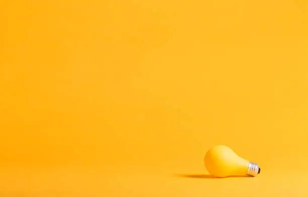 Photo of Yellow light bulb on a yellow background