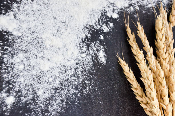 istock spilled flour and wheat ears on black background 841386010