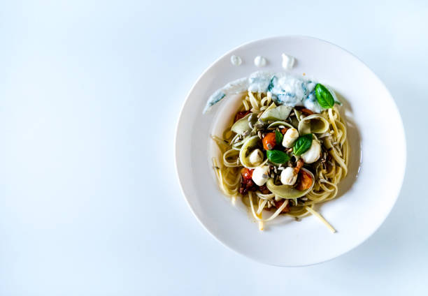 Top view of a pasta dish with mozzarella, tomatoes and basil.