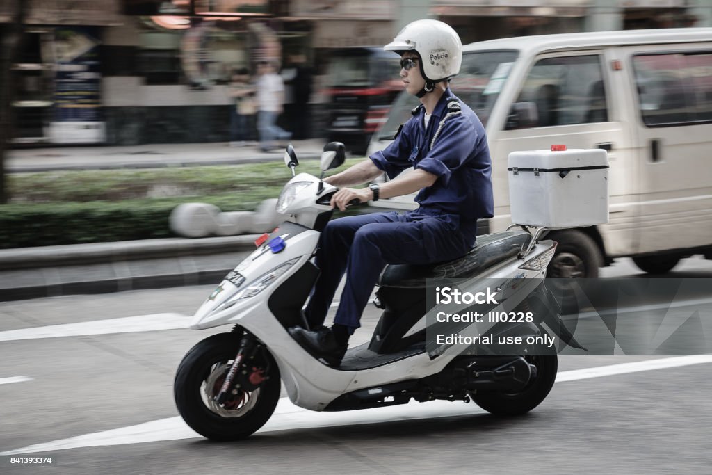 A Police Officer Patroling On A Scooter In Macau Photo - Download Image Now iStock
