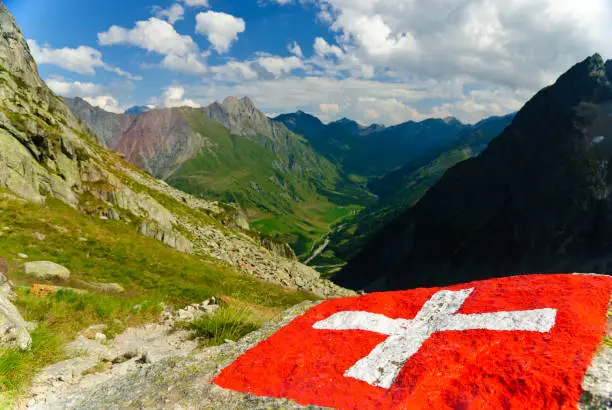 Swiss flag with view of the Val Ferret in Swiss Alps, Grand Saint Bernard Pass, Switzerland