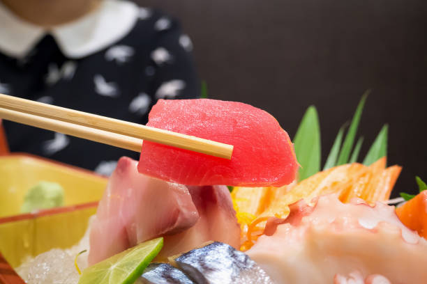 istock tuna in chopsticks with japanese sashimi set on boat plate 841397270