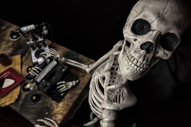 istock Halloween Skeleton At a Table with Typewriter, Phone and Cookies 841415460