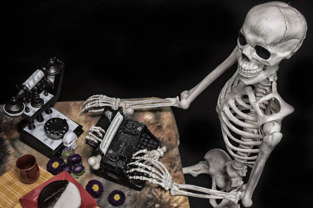 istock Halloween Skeleton At a Table with Typewriter, Phone and Cookies 841415466