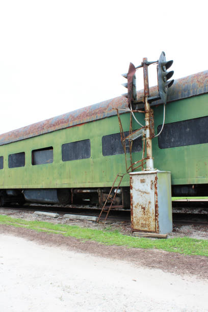 istock Vintage green railway passenger car with partially boarded windows and old railway track light 841419512