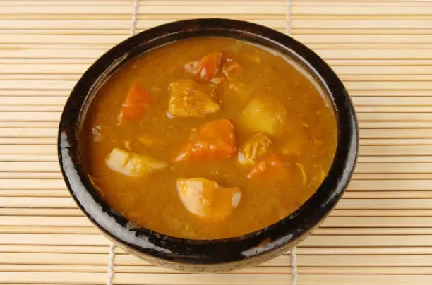 Chicken curry in black bowl