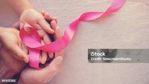 Adult And Child Hands Holding Pink Ribbons Breast Cancer Awareness Abdominal Cancer Awareness And October Pink Panoramic Background Stock Photo - Download Image Now
