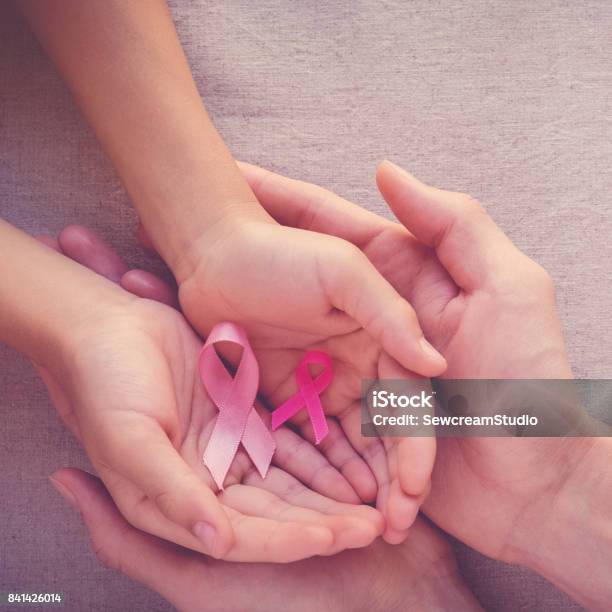 Adult And Child Hands Holding Pink Ribbons Breast Cancer Awareness Abdominal Cancer Awareness And October Pink Stock Photo - Download Image Now