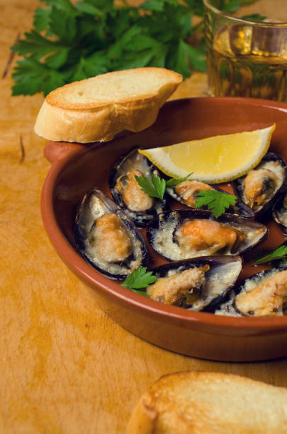 Baked mussels with cheese Baked mussels with cheese, parsley and lemon shells. Selective focus. kosher starter recipes stock pictures, royalty-free photos & images