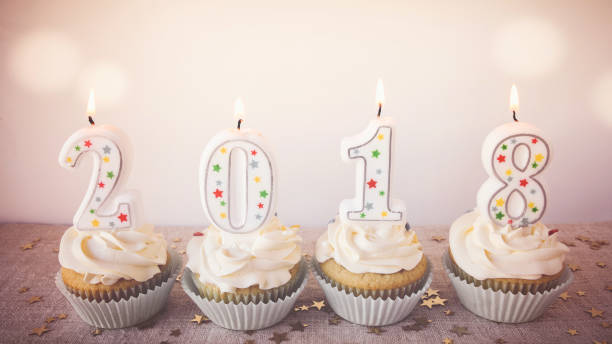 istock 2018 Happy New Year Cupcakes with fairy light toning background 841429026
