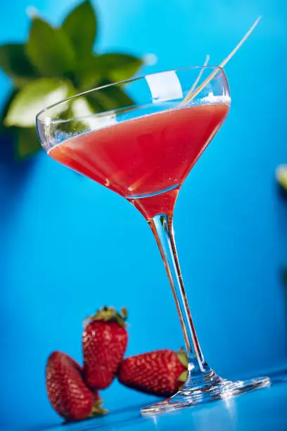 Summer Cocktail - Cosmopolitan Cocktail with Fresh Strawberry on Blue Background.
