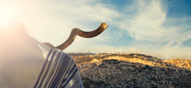 man blowing the Shofar with Jerusalem city view