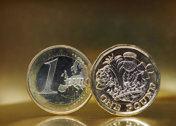 istock 1 pound and 1 euro coin over metal background 841441314