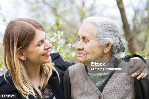 Happy Elderly Woman With Carer Outdoor Springtime Stock Photo - Download Image Now