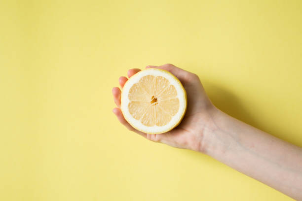 istock Lemon in woman's hand on a yellow background 841454470