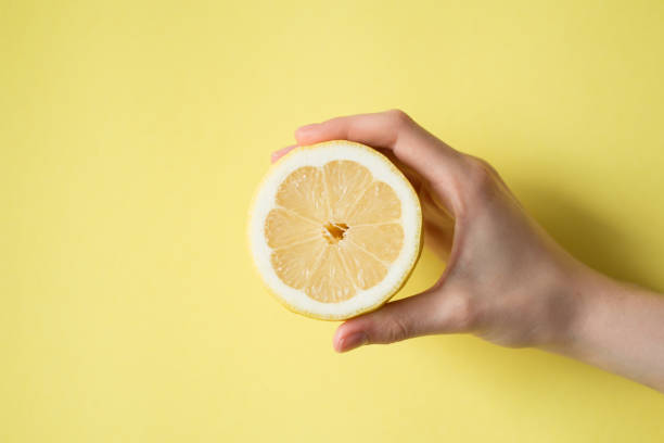 istock Lemon in woman's hand on a yellow background 841454498