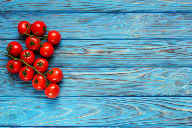 istock Red tomatoes on a blue wooden background. Vintage. 841461160