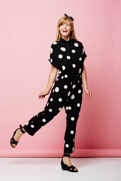 Spotted jumpsuit girl Blond girl in spotted jumpsuit posing in pink studio jumpsuit stock pictures, royalty-free photos & images