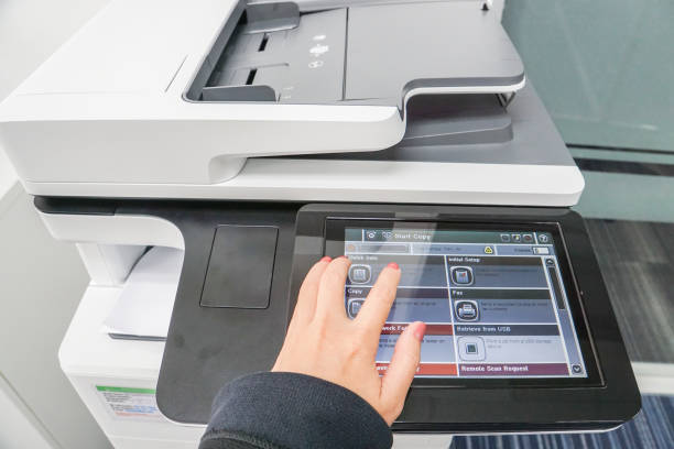 istock business woman with left hand press on printer touch screen for copying documents 841470784