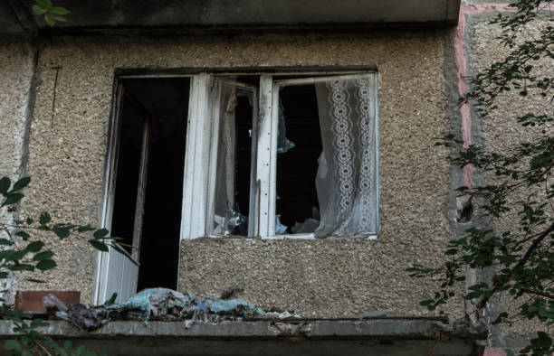 istock Broken window and balcony sawn in an abandoned apartment building. Debris devastation. 841471678