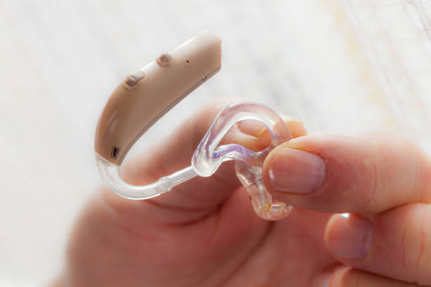 istock senior person holding hearing aid closeup 841471884