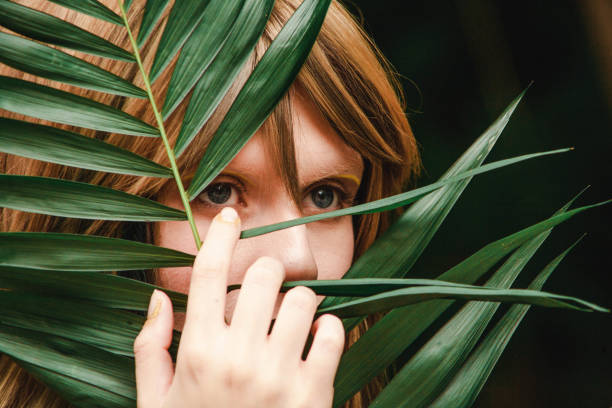 istock Large blue eyes model through the palm branch 841477912
