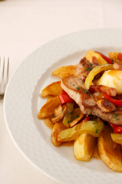 istock Pork and grilled vegetables arranged on a plate, Traditional dish in elegant setting, Selective focus with soft light 841478098