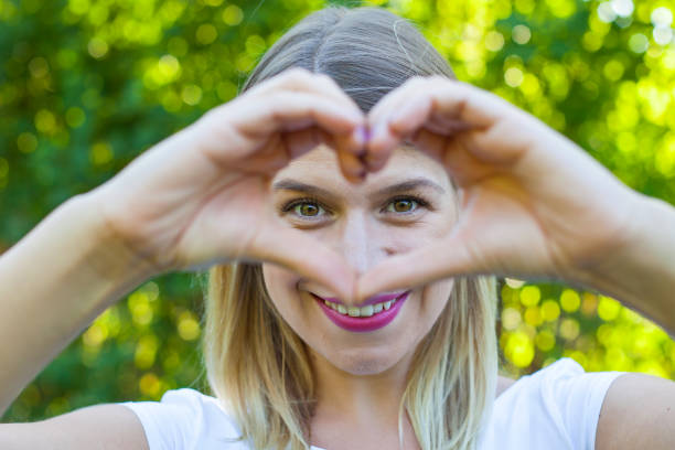 istock Cheerful woman showing a heart symbol with hands 841478732